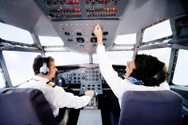 Pilots inside a cabin flying an airplane