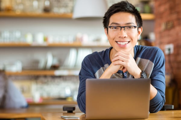Portrait of positive asian male in glasses with laptop in cafe-1